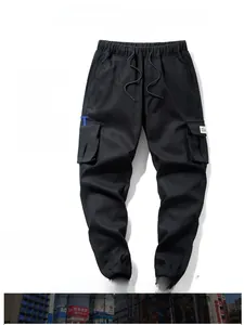 Detail of black cargo joggers featuring elastic drawstring waist and side flap pockets