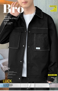 Close-up of black workwear jacket featuring white contrast stitching and snap button pockets