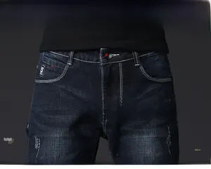 Detail of dark denim jeans waist showing white contrast stitching and R-logo coin pocket