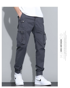 Detail of dark grey cargo pants featuring functional multi-pockets and elastic cuffs