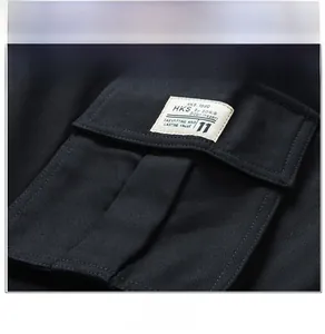 Detail of black cargo pants featuring a side pocket with an HKS white woven label