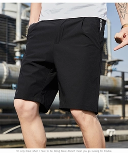 Gros plan sur un short décontracté noir pour hommes avec logo lettré blanc sur la poche