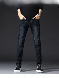 Detail of slim fit men's jeans in dark indigo with fading effect and whiskers texture