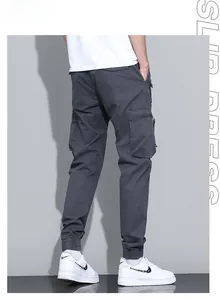 Detail view of charcoal grey cargo joggers featuring a side flap pocket and zipper