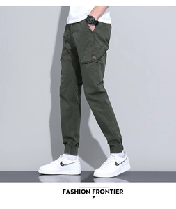 Detail view of dark green cargo pants with flap pocket and ribbed ankle cuffs