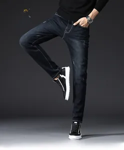 Detail of men's slim fit blue jeans showing whiskering and distressed texture on denim