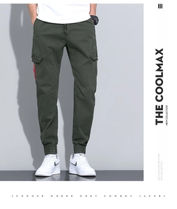Detail view of dark green cargo pants with large flap pocket and red label accent