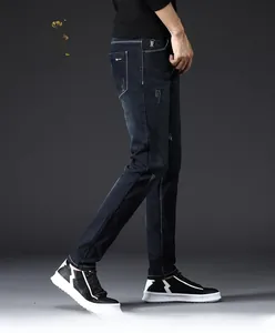 Detail shot of men's slim fit jeans showing vintage dark blue wash and subtle distressing
