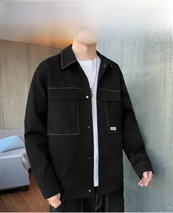 Detail of men's black workwear jacket featuring white contrast stitching and large pockets