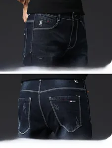 Detailed view of dark blue jeans featuring contrast stitching and vintage distressed pockets