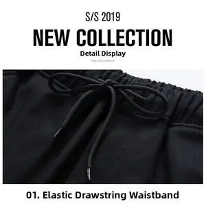 Detail view of black cargo pants featuring elastic waistband with metal tipped drawstrings