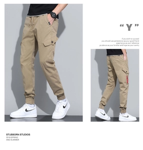 Detail of khaki cargo joggers showing drawstring waist and large side utility pockets