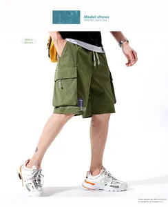 Detail view of cargo shorts in bean green with elastic waist and large flap pockets