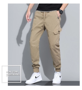 Detail of khaki cargo pants featuring elastic drawstring waist and large side utility pockets
