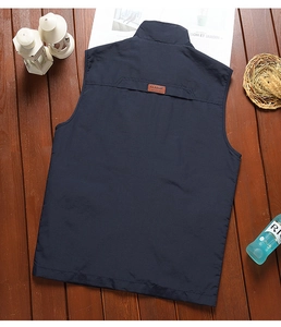 Detail view of the deep blue outdoor vest back featuring a classic leather logo patch