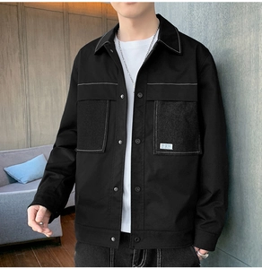 Close-up of black casual jacket with contrast stitching and large chest pockets
