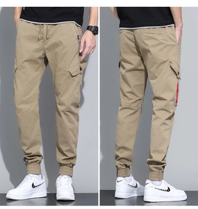 Detail view of khaki cargo pants featuring elastic cuffs and red contrast zipper pocket