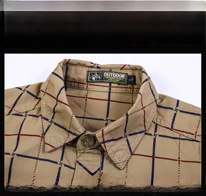 Close-up of khaki plaid shirt collar with outdoor woven label and dark metal buttons