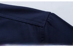Macro shot of navy blue cotton shirt showing shoulder stitching and fine fabric texture
