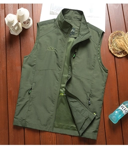 Detailed close-up of dark green outdoor vest featuring embroidery logo and zipper pocket