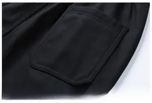 Detailed close-up of the minimalist back pocket stitching on black cargo pants for men