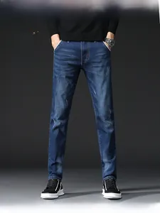 Detailed close-up of slim fit denim jeans in dark blue with subtle wash and cat-whisker effect