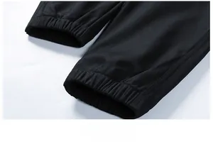 Detailed macro view of the elastic jogger cuffs on black twill cargo trousers for men