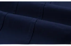 Detailed macro view of dark blue cotton fabric texture and clean stitching of the shirt