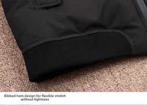 Close-up of black down jacket featuring elastic ribbed hem on a textured background
