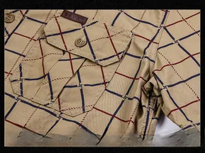 Close-up of khaki plaid shirt featuring a functional chest pocket and outdoor leather patch