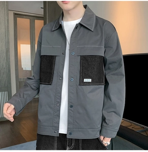 Detail of grey vintage workwear jacket showing black chest pocket with white stitching