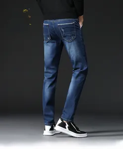 Detailed view of men's slim fit dark blue jeans with distressed wash and V-shaped pockets