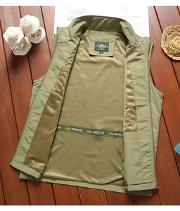 Close-up of olive green outdoor vest with breathable mesh lining and brand webbing