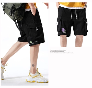 Detail of black cargo shorts featuring white text print and adjustable drawstring waist