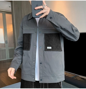 Detail of grey vintage jacket showing large black contrast pockets and a white woven label
