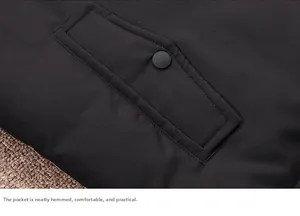 Detailed close-up of a black down jacket pocket with matte snap button and fine stitching
