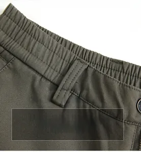 Detailed view of dark green men's casual pants showing elastic waist and belt loops