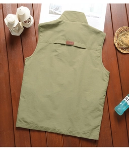 Detail of army green fishing vest with breathable back vent and leather classic label