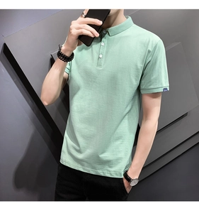 Close-up of mint green polo shirt collar with three buttons and blue woven label on sleeve