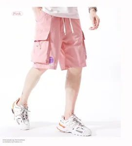 Detail of pink cargo shorts with elastic drawstring waist and side utility pockets