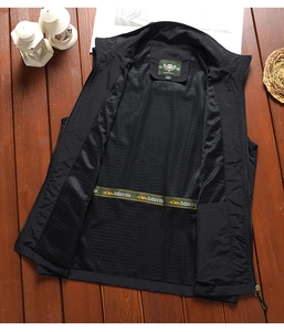 Detail of breathable mesh lining and brand label on a black outdoor fishing vest