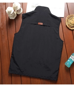 Detail of classic black outdoor vest showing the standing collar and leather back patch