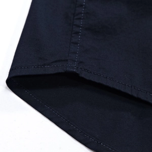 Close-up of double-stitched hem on navy blue men's short-sleeved casual shirt