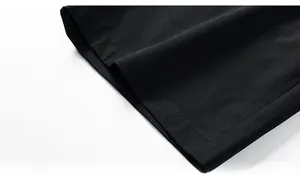 Gros plan sur l'ourlet du short noir pour homme montrant la texture sergée de qualité
