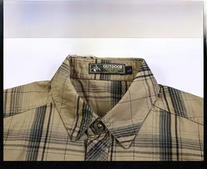 Detail shot of khaki plaid men's shirt collar with premium stitching and retro buttons