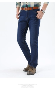 Detail of men's dark blue straight jeans with whiskers and sandblasted finish on thighs