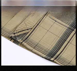 Macro detail of khaki plaid cotton fabric showing straight and firm hemline stitching