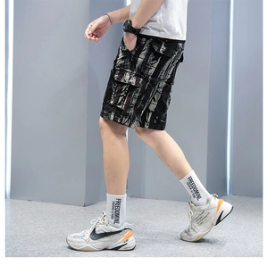 Detail of cargo shorts showing camo dye pattern and large side flap pockets on the fabric