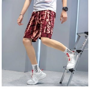 Detail of burgundy cargo shorts with abstract prints and large side utility pockets