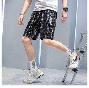 Detail of cargo shorts with black, white and grey camo pattern and large side flap pockets